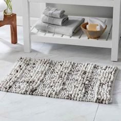 a bathroom with white and gray towels on the floor