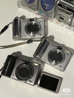 three cameras sitting next to each other on a table