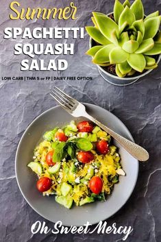 a plate with salad on it next to a potted succulent and a fork