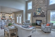 a living room filled with furniture and a fire place in front of a kitchen area