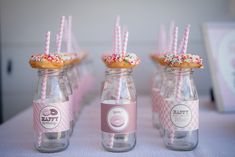 three glass jars with donuts and straws in them