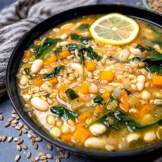 a bowl of soup with beans, spinach and lemon