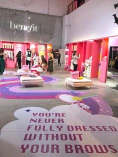 a group of people standing in front of a store with signs on the floor that read you're never dressed without your brows