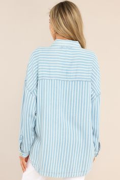 Looking for an effortless classic? This Always Lovely Blue Striped Top is your go-to for effortless, casual style. Throw it on and get ready for the compliments! This top features a collared neckline, functional buttons down the front, two functional bust pockets, long sleeves with buttoned cuffs, a scoop bottom hem, and a super soft material. 100% Lyocell Hand Wash Cold Unlined Imported Model is wearing a small Cotton T-shirt With Striped Collar, Relaxed Fit, Washed Blue Cotton Blouse, Relaxed Fit, Relaxed Fit Button-up Top With Striped Cuffs, Blue Cotton T-shirt With Contrast Stripes, Blue Striped Top, Nude Bra, Blue Horizontal Stripe Cotton T-shirt, Top Hits, Chambray Top