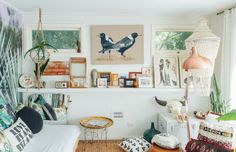 a living room filled with lots of furniture and pictures on the wall above it's headboard