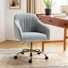 a blue office chair sitting on top of a wooden floor next to a desk with a potted plant