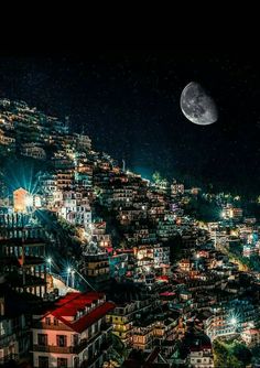 the full moon shines brightly in the night sky over a city with many buildings