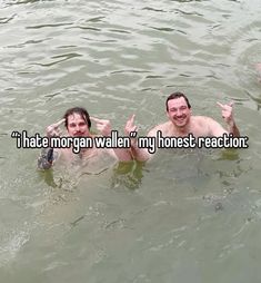 two people in the water with their hands up