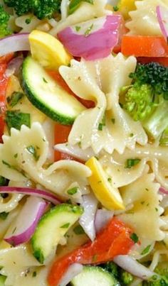 a pasta salad with broccoli, carrots, red onions and cucumbers