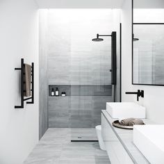 a white bathroom with two sinks and mirrors on the wall next to it's walk in shower