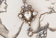 This dazzling antique diamond pendant was made in Germany and dates to the mid-19th century. The stunning central pear-shaped 'fancy light yellow' rose cut diamond weighs approx. 1.5ct. (SI 1) and is set in a crimpled rubover silver setting. Surrounding the central stone at the furthermost point of each cardinal direction are four slightly smaller round 'light fancy yellow' rose cut diamonds (SI 1) (the uppermost being slightly more white), with a total approximate weight of 1.1ct. The spaces in Luxury Victorian Rose Cut Diamond Necklace, Luxury Vintage Yellow Gold Diamond Necklace, Yellow Diamond Necklace, Fancy Light, Victorian Pendants, Fancy Lights, Fancy Yellow Diamond, Round Light, Gold Diamond Necklace