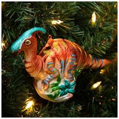 a dinosaur ornament hanging on a christmas tree