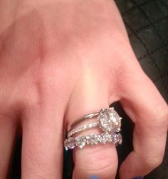 a woman's hand with two diamond rings on her left and the middle finger