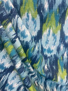 the fabric is blue and green with an abstract design on it's side,