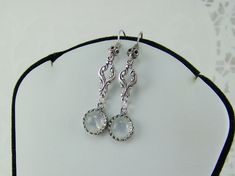 "Round set AAA quality natural rainbow moonstone gemstones highlight these elegant dangle earrings. The 8mm moonstones are suspended from antique oxidized silver scroll connectors. These dazzling moonstones are set in silver JBB crown bezels. Oxidized silver earwires have a filigreed ball. These earrings measure 1 3/4\" in overall length. The iridescent round rainbow moonstone are set in a sterling crown bezel. These earrings have a rainbow sparkling appearance. These lovely earrings would make Nickel-free Moonstone Dangle Jewelry, Elegant Nickel-free Moon-shaped Earrings, Elegant Nickel-free Moon Shaped Earrings, Elegant Adjustable Moon Shaped Earrings, Elegant Hypoallergenic Moon-shaped Jewelry, Elegant Hypoallergenic Moon Shaped Earrings, Elegant Hypoallergenic Moon Shaped Jewelry, Nickel-free Moonstone Moon-shaped Earrings, Nickel-free Moonstone Moon Earrings