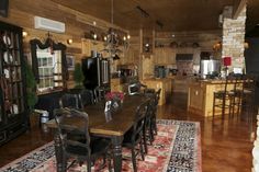 a dining room table and chairs in a large kitchen with wood paneling on the walls