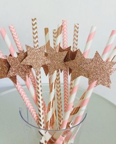 pink, gold and white paper straws with glitter stars in a clear glass vase