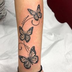 a woman's leg with black and white butterflies tattooed on the side of it