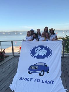 the girls are holding up a giant ford banner