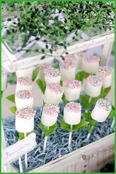 cake pops with sprinkles on them in a display case at a wedding