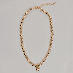 "This trendy ball chain necklace embellished with a puffy heart charm is the perfect statement necklace. Measurements - Chain length: 14.5\" inches with a 2\" inch extension chain (16.5\" inches total) - Bead width: 6mm - Puffy Heart Charm: 1.2\" inch Materials - Chain material: gold plated - Lead & nickel free - Handmade in Los Angeles Care: We do recommend keeping plated jewelry as dry as possible, as you run the risk of tarnishing when you allow the metal to react with any other liquids. Trendy Gold Beaded Necklaces With Heart Beads, Trendy Gold Beaded Necklace With Heart Beads, Necklace Choker Gold, Puffy Heart Necklace, Gold Ball Chain, Heart Necklace Gold, Necklace Measurements, Sideways Initial Necklace, Puffy Heart Charms