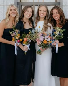 the bridesmaids are all wearing black dresses and holding bouquets