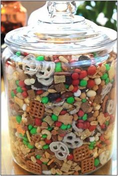 a glass jar filled with lots of different types of cereal and pretzel treats