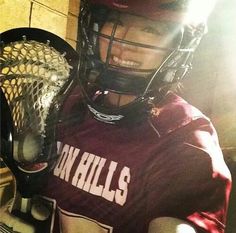 a young man wearing a helmet and holding a lacrosse racquet in his hand