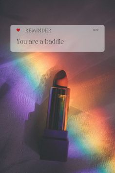 a lipstick with the words you are a baddie on it and rainbow light coming from behind