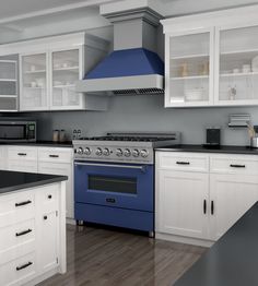 a blue stove top oven sitting inside of a kitchen next to white cabinets and counter tops