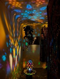 a room with colorful lights on the walls and a plant in the middle of it