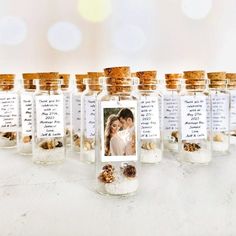 there are many small bottles with pictures in them on the table, one is filled with nuts