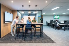 three people sitting at a table in an office