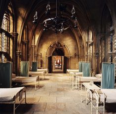 an old church with many beds and chairs in it's center aisle, as well as a chandelier hanging from the ceiling