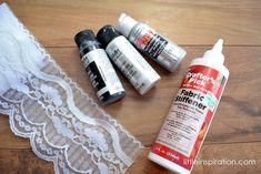 some craft supplies are laying on a wooden floor next to lace and glues,