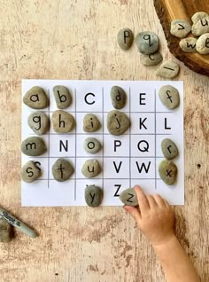 a child is playing with rocks and letters