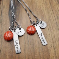 three different necklaces with names on them sitting on top of a wooden table next to each other