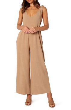 Elevate your contemporary wardrobe with this tie-shoulder linen jumpsuit finished with wide legs and handy side pockets. Pull-on style Adjustable tie straps Side-seam pockets Unlined 100% linen Hand wash, dry flat Imported Chic Beige Linen Jumpsuits And Rompers, Linen Jumpsuit For The Beach, Linen Jumpsuits And Rompers For Summer, Solid Color Linen Jumpsuits And Rompers For Summer, Brown Sleeveless Overalls For Summer, Wide Leg Overalls For Summer, Wide Leg Linen Jumpsuits And Rompers, Beach Linen Wide Leg Jumpsuits And Rompers, Linen Wide Leg Jumpsuits For Beach