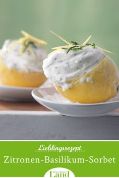 two lemon cupcakes with white frosting and green sprigs on top