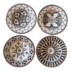 four black and white plates with designs on them