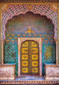 an ornate entrance to a building with gold and green doors, decorated with intricate designs