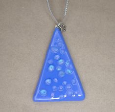 a blue triangle shaped pendant with small bubbles on it's side and a star hanging from the front