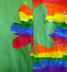 the paper is cut out to look like a shamrock on a rainbow colored sheet of paper