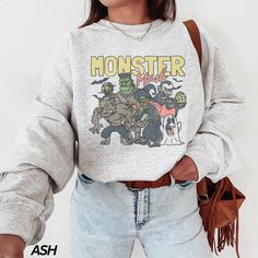 "Monster Mash Sweatshirt * Processing time is approx 1-7 business days (there may be exceptions during holiday seasons). Delivery time is based on your shipping type selection and location. Please check the estimated delivery times at checkout and upgrade the shipping at checkout if you need it sooner. * All items are made-to-order. Because of the nature of these items, unless they arrive damaged or defective, we cannot accept return or exchange. * Please review the all size charts displayed in the product images.  * Please note that the sizing chart includes the measurements of one side of the shirt, not the circumference.  * Sizing might differ 1\" (+-) from brand to brand. We recommend you to size up of you're between two sizes. Ideal for any situation, a unisex heavy blend crewneck swe Halloween Crew Neck Top With Graphic Print, Halloween Streetwear Crew Tops, Halloween Apparel, Monster Mash, Ghost Shirt, Sweatshirt Cute, Sweatshirt Vintage, Halloween Tees, Halloween Sweatshirt