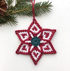 a crocheted christmas ornament hanging from a pine tree