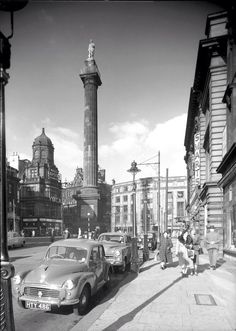 an old black and white photo of cars parked on the street