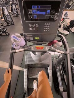 a person on a stationary exercise bike in a gym with treads and other equipment