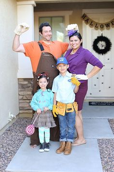 a man and two children are standing in front of a house with an apron on