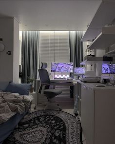 a bedroom with a bed, desk and computer monitor in it's center area