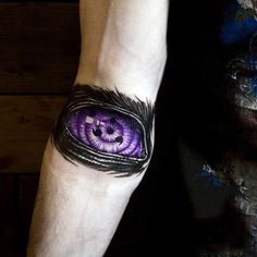 a man with a purple eye tattoo on his arm